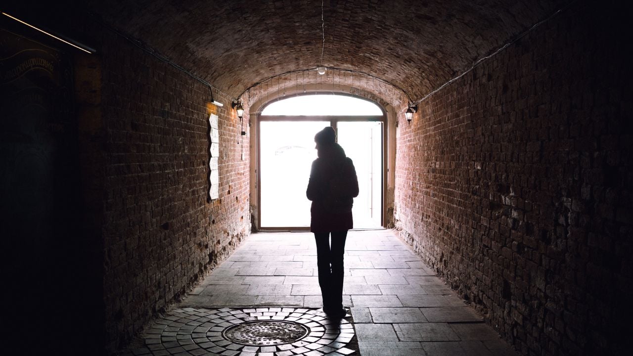 Person walking down a dark tunnel.